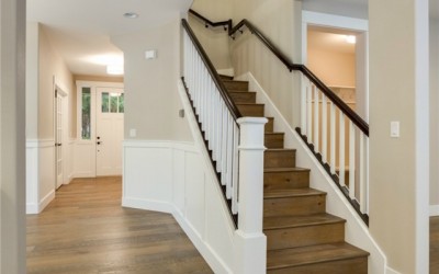 The spindle railing with stained handrails adds traditional eleg
