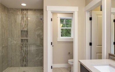 The open tile shower has a swinging glass door creating a clean,