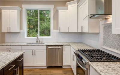 Kitchen features full-height tile and decorative mosaic backspla